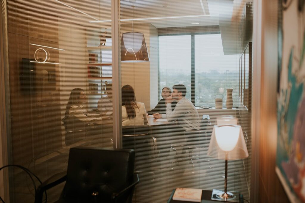 Reunião na sala da Integrity Wealth Management, vista pela persiana
