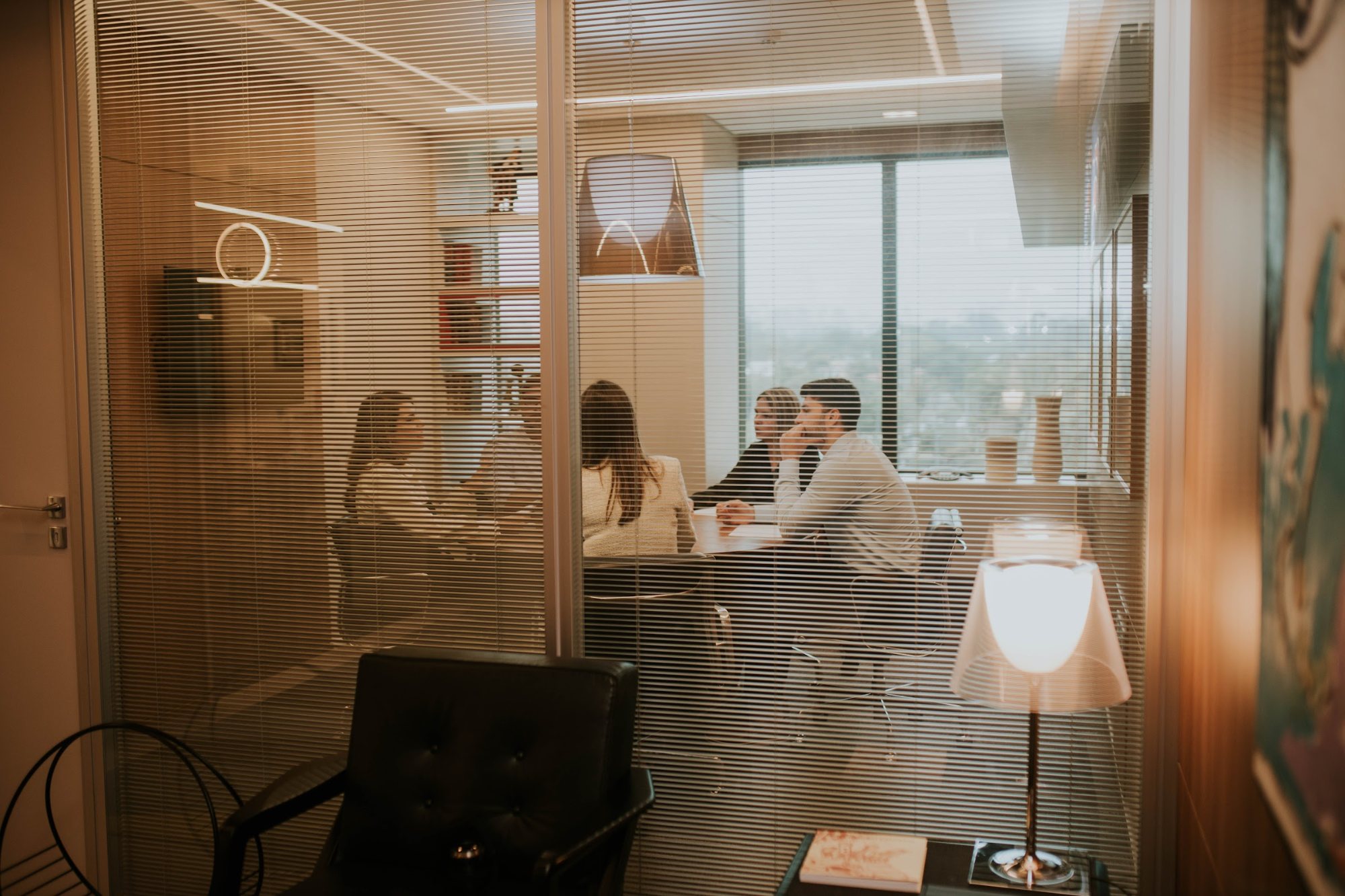 Reunião na sala da Integrity Wealth Management, vista pela persiana, no Itaim Bibi, em São Paulo